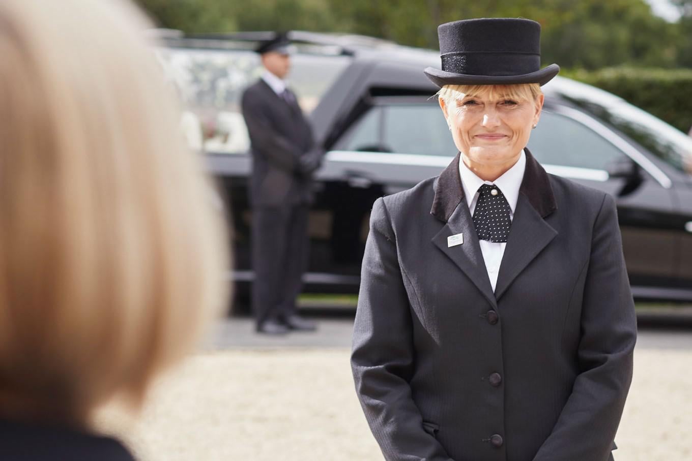 A female funeral arranger sits with a family to arrange a funeral.